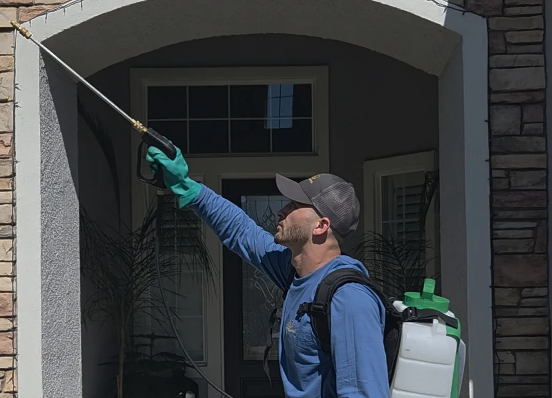 Summit Pest Control technician treating the entryway of a home
